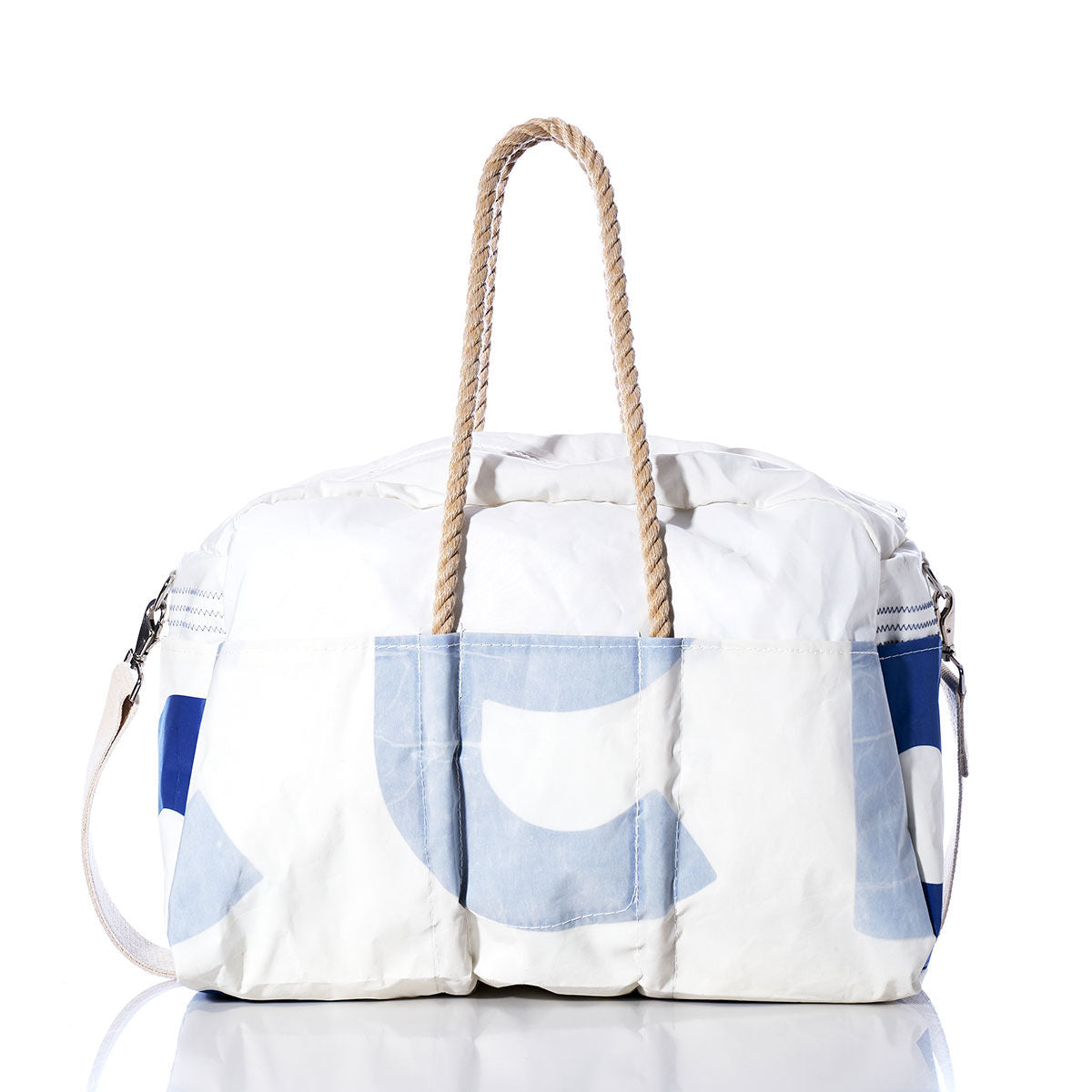 The Sea Bags Vintage US Weekender, featuring white and blue hues with rope handles and a convenient shoulder strap, is displayed on a reflective surface against a white background—bringing vintage charm to your next getaway. by Sea Bags