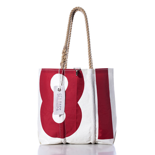 Introducing the Sea Bags Vintage 81 Medium Tote: a Maine-crafted bag featuring a classic white and red sail design with a bold number 81, hand-spliced rope handles, and a signature white SEA BAGS tag. This tote combines timeless nautical style with durable functionality. by Sea Bags