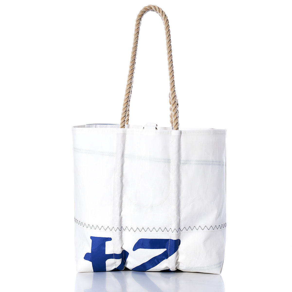 The Sea Bags Vintage J24 Medium Tote features a white sailcloth design with a sturdy rope handle and blue printed characters near the base, echoing nautical charm. Handmade in Maine, this timeless tote is photographed against a white background, capturing its blend of practical elegance and classic style. by Sea Bags