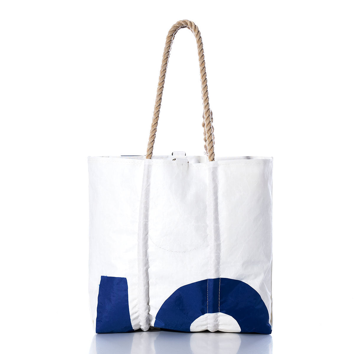 The Sea Bags Vintage 95 Medium Tote is a white tote made from textured material, featuring a blue geometric design and hand-spliced rope handles. Photographed on a white background, this bag draws inspiration from classic Maine craftsmanship, blending nautical charm with timeless style. by Sea Bags
