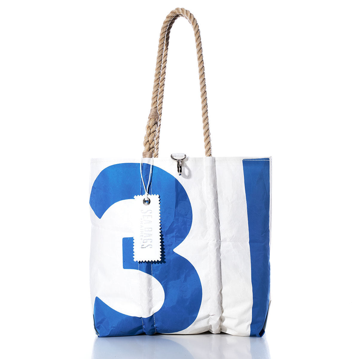 The Sea Bags Vintage 31 Medium Tote is a handcrafted Maine bag inspired by vintage sail totes, featuring white and blue panels, a prominent number 31 on the front, sturdy hand-spliced rope handles, and a white tag near the handle. by Sea Bags