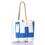 The Sea Bags Vintage Blue E Medium Tote features a blue geometric design on white sailcloth, hand-spliced rope handles, and a white tag near the top. This Maine-crafted tote stands upright against a white background. by Sea Bags