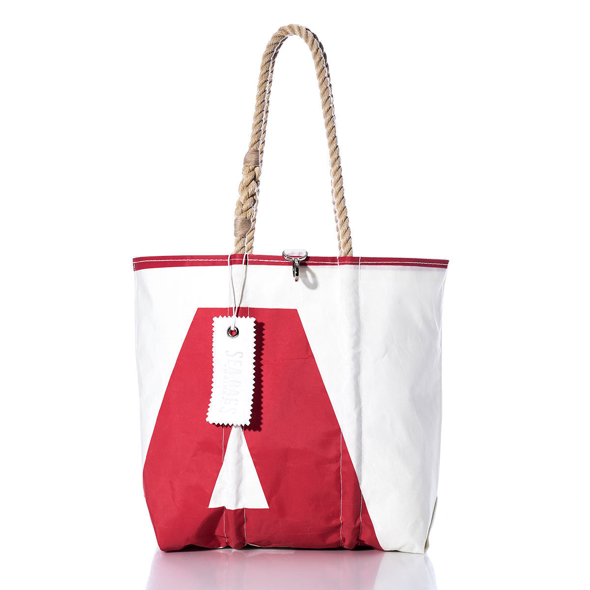 Sea Bags Vintage A9 Medium Tote, a handmade bag from Maine, features white and red recycled sailcloth with a bold letter A design, sturdy rope handles, and a white tag attached to one handle. Photographed on a white background, this tote is crafted for both style and durability. by Sea Bags