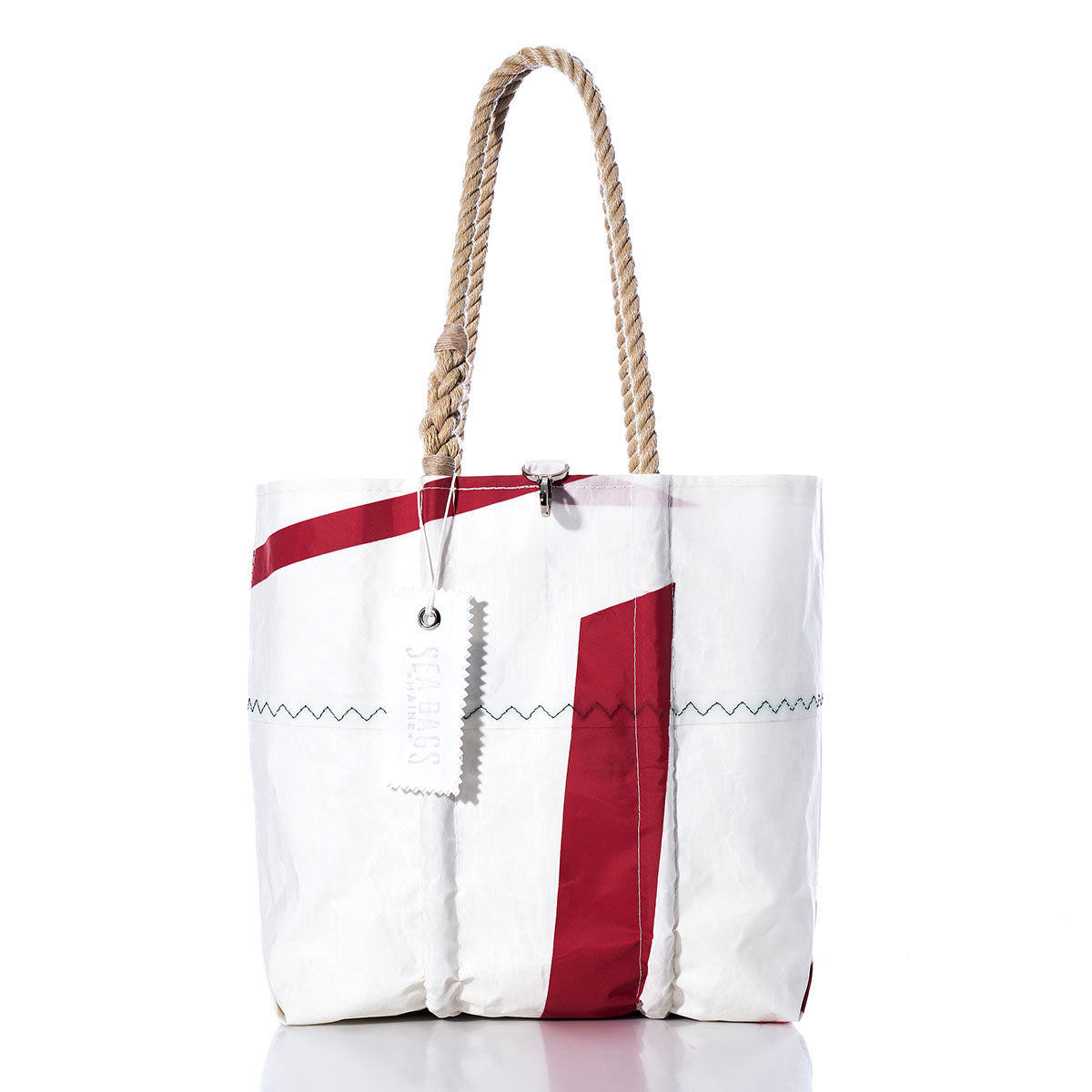 Sea Bags Vintage Red 7 Medium Tote features a white sailcloth exterior with bold red diagonal stripes, braided rope handles, a rectangular tag, and visible stitching. Beautifully handmade in Maine, this tote has a distinctive crinkled texture that highlights its unique character. by Sea Bags