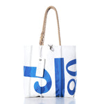 White tote bag featuring blue graphic designs, a sturdy rope handle, visible stitching, and a rectangular tag near the top handle. The handcrafted Sea Bags Vintage J80 Medium Tote captures timeless style and utility—ideal as a classic sailboat-inspired tote for everyday adventures. by Sea Bags