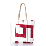 Sea Bags’ Vintage 559 Medium Tote is displayed on a plain white background, featuring a red geometric design inspired by original sail insignia, hand-spliced rope handles, and a rectangular white tag—an authentic maritime tote crafted from vintage sails. by Sea Bags