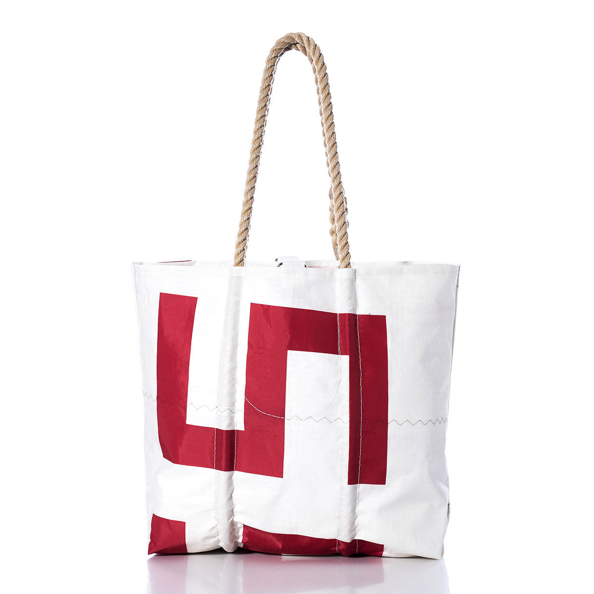 The Sea Bags Vintage 559 Medium Tote is crafted from genuine sails, featuring a white exterior with bold red geometric designs and original sail insignia. It is finished with sturdy hand-spliced rope handles and shown against a white background. by Sea Bags