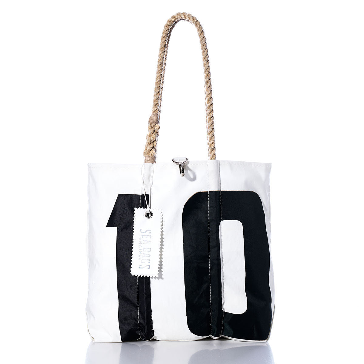 Sea Bags Vintage 10 Medium Tote features hand-spliced rope handles, a large black number 10 on the front, and a white rectangular tag. Meticulously crafted in Maine from vintage sailcloth, this tote blends durability with timeless coastal style. by Sea Bags