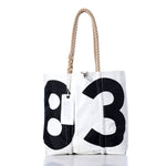 The Vintage 83 Medium Tote by Sea Bags is a white sailcloth bag with thick rope handles, featuring large black numbers 8 and 3 on the front and a SEA BAGS tag attached to one handle; this handmade bag is crafted in Maine. by Sea Bags