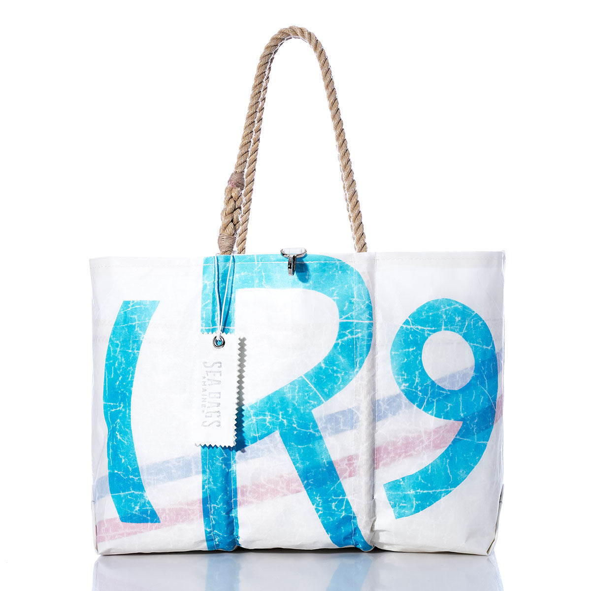 Vintage Rhodes 19 Large Tote by Sea Bags, handcrafted in Maine from recycled sails, features blue and red lettering, sturdy rope handles, and a silver Sea Bags tag; photographed on a white background. by Sea Bags