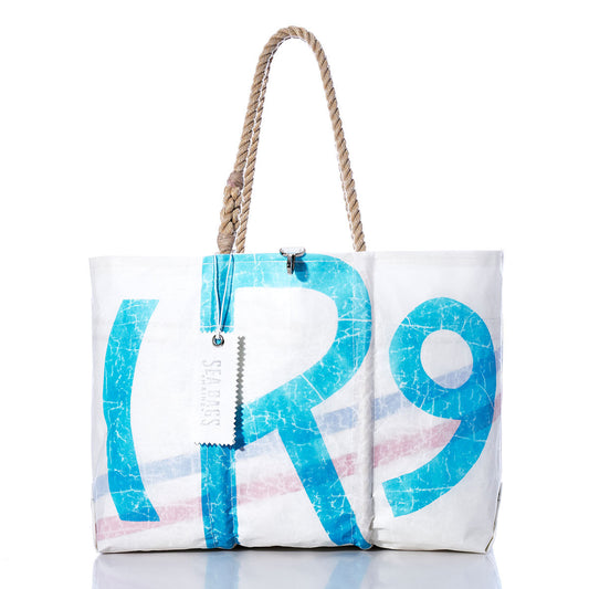 Vintage Rhodes 19 Large Tote by Sea Bags, handcrafted in Maine from recycled sails, features blue and red lettering, sturdy rope handles, and a silver Sea Bags tag; photographed on a white background. by Sea Bags
