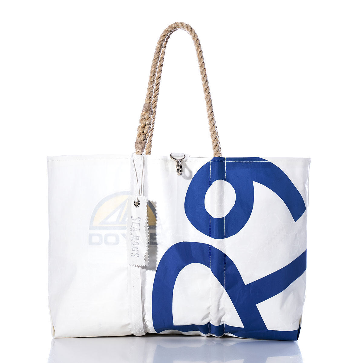 Sea Bags Vintage Rhodes 19 Large Tote, crafted from white sailcloth with a blue number 29 design, features sturdy rope handles and a signature branded tag. Handmade in Maine, it is pictured against a white background. by Sea Bags