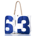 Sea Bags Vintage Blue 63 Large Tote: A white tote bag crafted by Sea Bags, featuring bold blue numbers 6 and 3 as an authentic sail insignia, hand-spliced rope handles, and a white tag attached—displayed on a white background. by Sea Bags