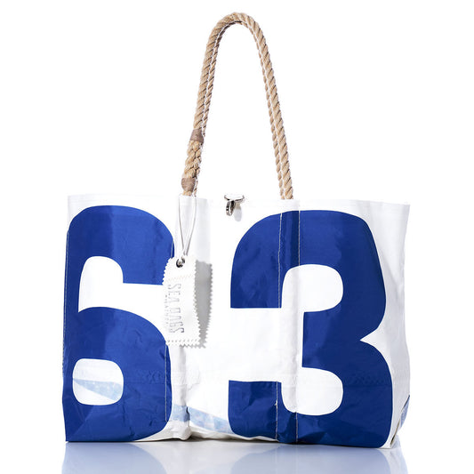 Sea Bags Vintage Blue 63 Large Tote: A white tote bag crafted by Sea Bags, featuring bold blue numbers 6 and 3 as an authentic sail insignia, hand-spliced rope handles, and a white tag attached—displayed on a white background. by Sea Bags