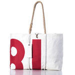 Sea Bags’ Vintage 81 Large Tote features a bold red design on white sailcloth, hand-spliced rope handles, and a white tag, all displayed against a white background. Proudly crafted in Maine. by Sea Bags