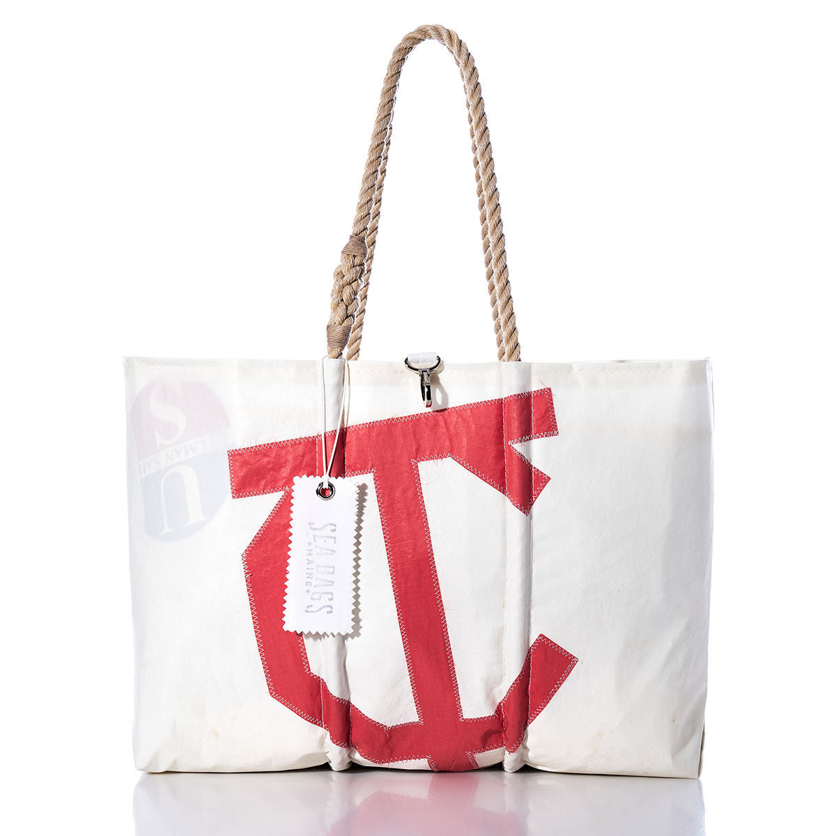 Introducing the Vintage Town Class Large Tote by Sea Bags—a white canvas bag handcrafted in Maine, distinguished by a bold red C on the front. It features hand-spliced rope handles and a signature white SEA BAGS tag on one handle, seamlessly combining style with exceptional durability. by Sea Bags