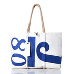 The Vintage J80 Large Tote by Sea Bags is a classic handcrafted Maine bag made from durable sailcloth, featuring bold blue numbers and sturdy rope handles. Displayed on a white background with a small white tag attached, this white tote combines timeless style and practical functionality. by Sea Bags
