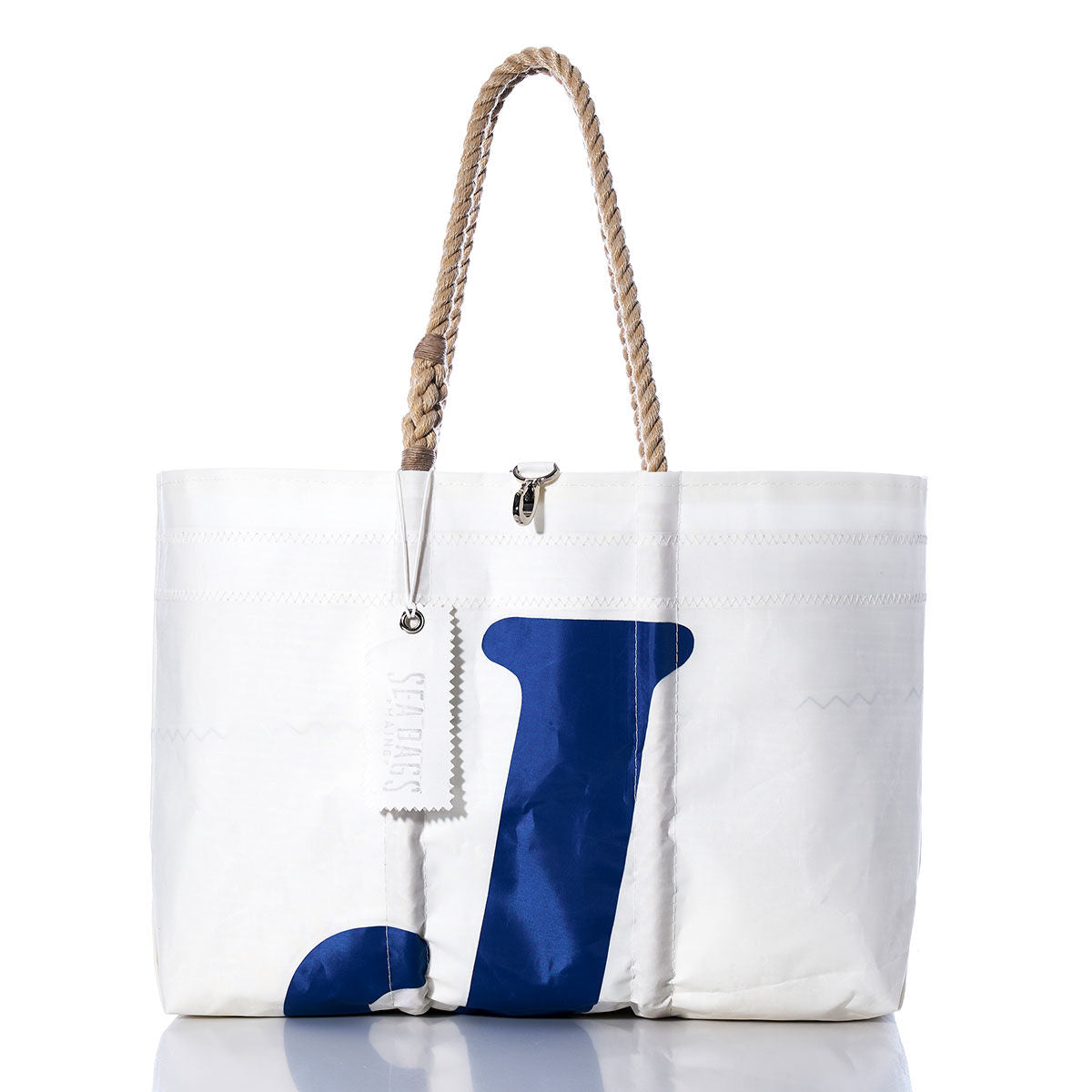Sea Bags Vintage J70 Large Tote, handcrafted in Maine from white sailcloth with sturdy rope handles, features a bold blue letter J on the front and includes a hang tag attached to one handle. by Sea Bags