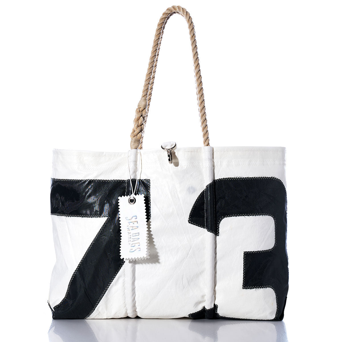 The Sea Bags Vintage 73 Large Tote, crafted in Maine from vintage sail cloth, features black 73 artwork, hand-spliced rope handles, and a signature Sea Bags tag. It is shown on a white background. by Sea Bags