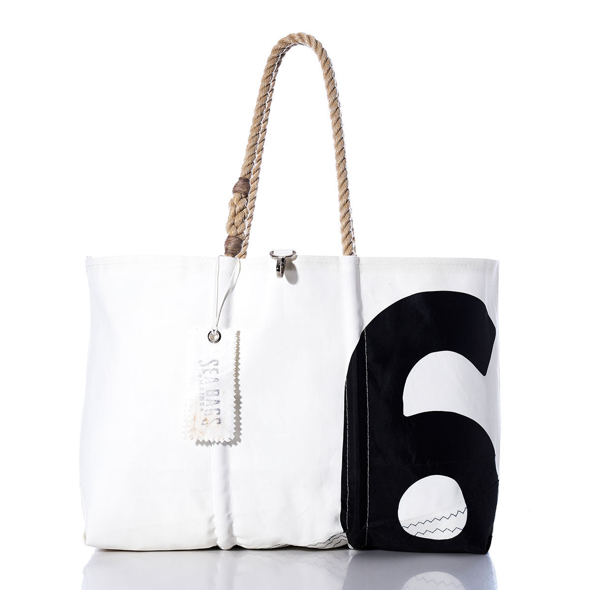 The Sea Bags Vintage Black 6 Large Tote is a white tote bag crafted with hand-spliced rope handles, featuring a bold black number six graphic on the right side and finished with a white tag near the handle—genuine vintage sail style inspired by authentic sail insignia. by Sea Bags