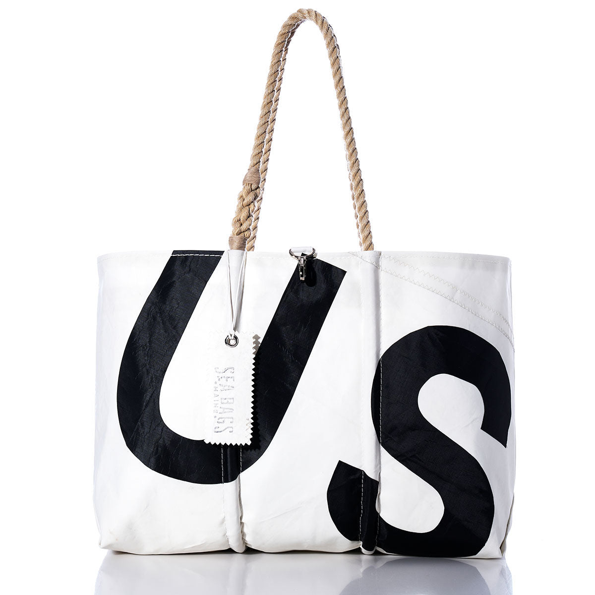 The Sea Bags Vintage US Large Tote features durable white sailcloth, bold black U and S letters, tan rope handles, and a white tag with text. Expertly crafted in the style of handmade Maine bags, this tote is photographed on a white background. by Sea Bags