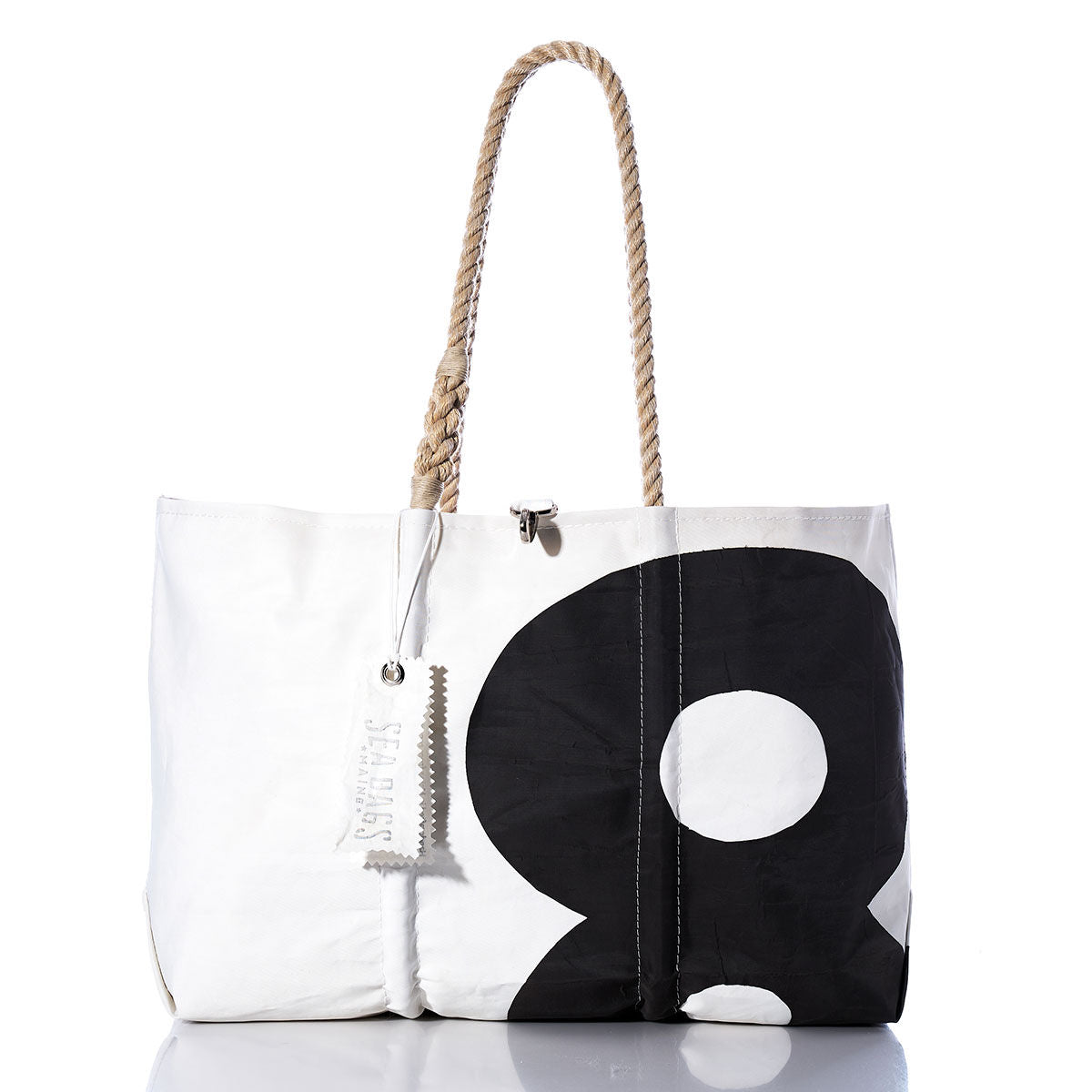 Introducing the Sea Bags Vintage Black 8 Large Tote, crafted from recycled sails with original sail insignia and hand-spliced rope handles. This spacious white and black tote features a striking number 8 graphic and includes a distinctive white tag. Photographed on a plain white background. by Sea Bags