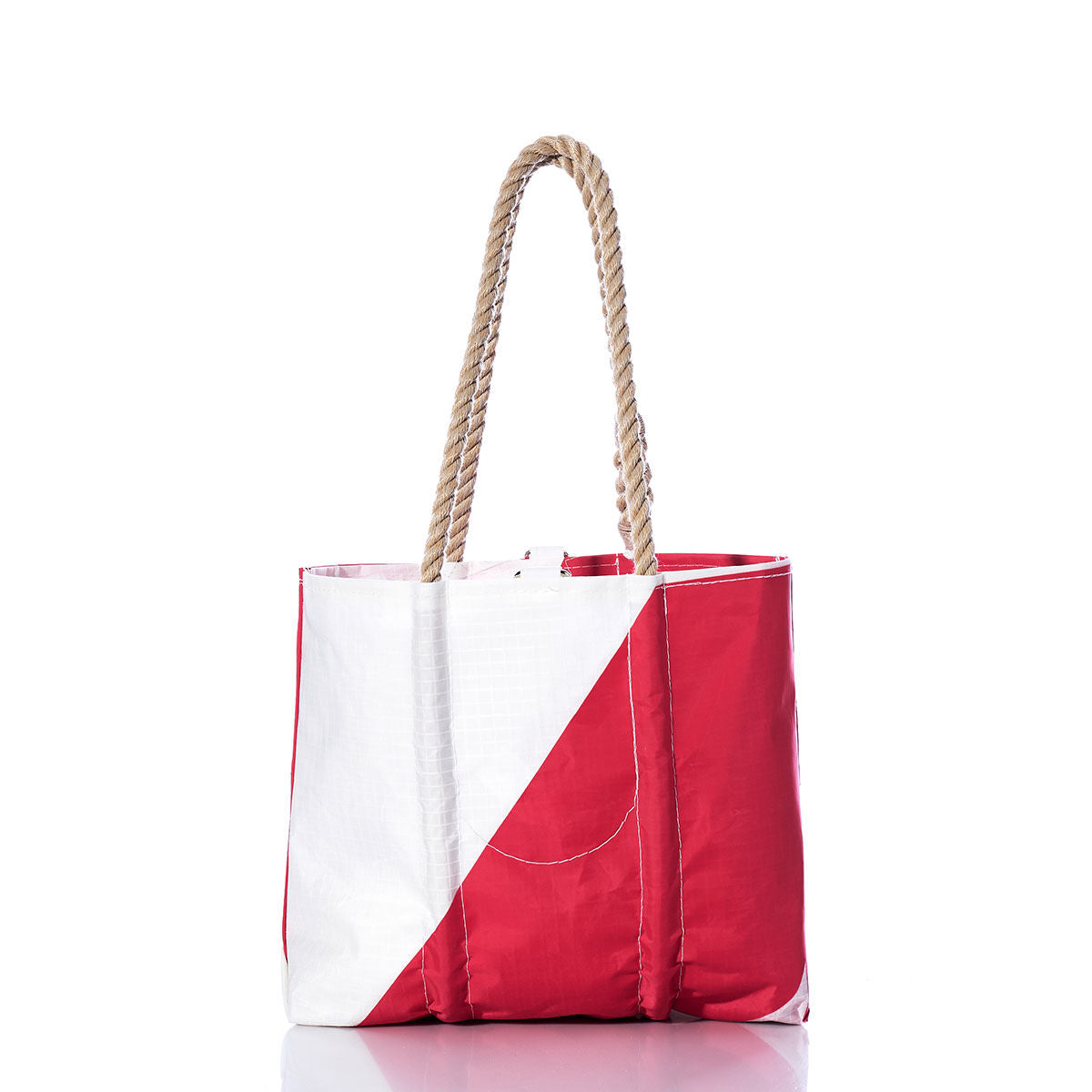 The Sea Bags Vintage Pink and White Handbag features a bold diagonal split between pink and white, accented by hemp rope handles that evoke classic sailing gear, and finished with a circular stitch detail inspired by vintage handbag styles—all presented against a plain white background. by Sea Bags