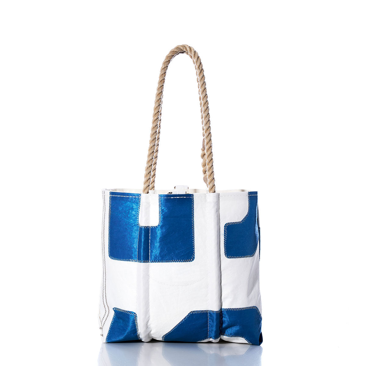 Sea Bags Vintage 15 Handbag, a white and blue tote with hemp rope handles, showcases patchwork-style designs and a subtle sail insignia, displayed upright on a white background. by Sea Bags