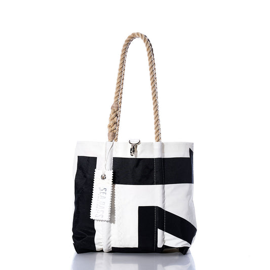 Sea Bags Vintage International 14 Handbag – a black and white tote with durable hemp rope handles and an attached white tag. Displayed on a white background with a slight reflection, this stylish accessory draws inspiration from classic International 14 handbag designs and is adorned with subtle sail insignias for an elegant nautical flair. by Sea Bags