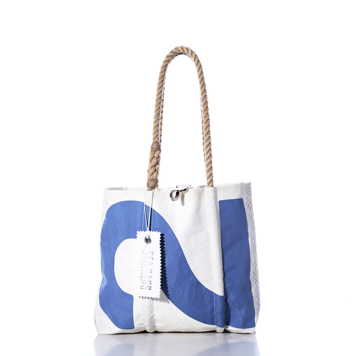 The Sea Bags Vintage 22 Handbag is a white tote bag with a blue curved print, sturdy hemp rope handles, and a “Sea Bags” tag attached to one handle, photographed on a white background. by Sea Bags