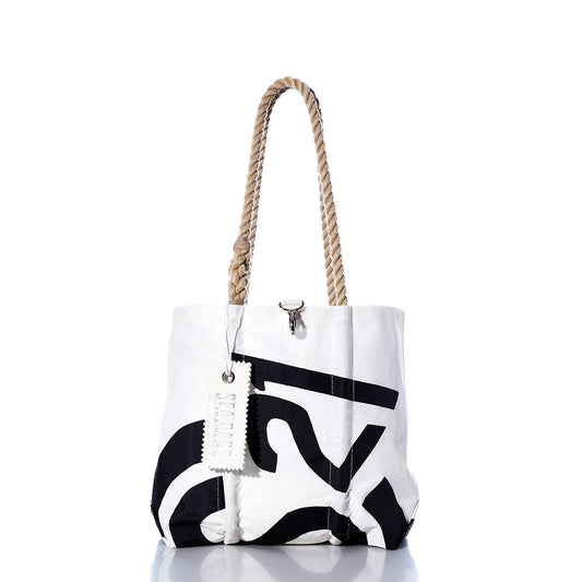 White tote bag with bold black print, hemp rope handles, and a white tag hanging from one handle, photographed on a white background with a subtle reflection below. The Sea Bags Vintage CS21 Handbag is inspired by classic sail insignias, blending timeless style with nautical flair. by Sea Bags