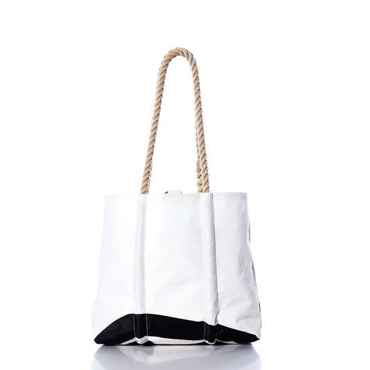 White tote bag with sturdy hemp rope handles and a black bottom, shown on a white background with a subtle reflection below. The Sea Bags Vintage CS21 Handbag showcases classic sail insignias, bringing a nautical flair to its timeless design. by Sea Bags