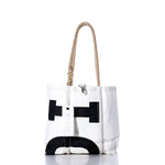 Sea Bags Vintage Interclub Handbag—a white tote bag with black geometric designs, hemp rope handles, and a silver clasp—stands upright on a white background, offering a modern twist on a classic style. by Sea Bags