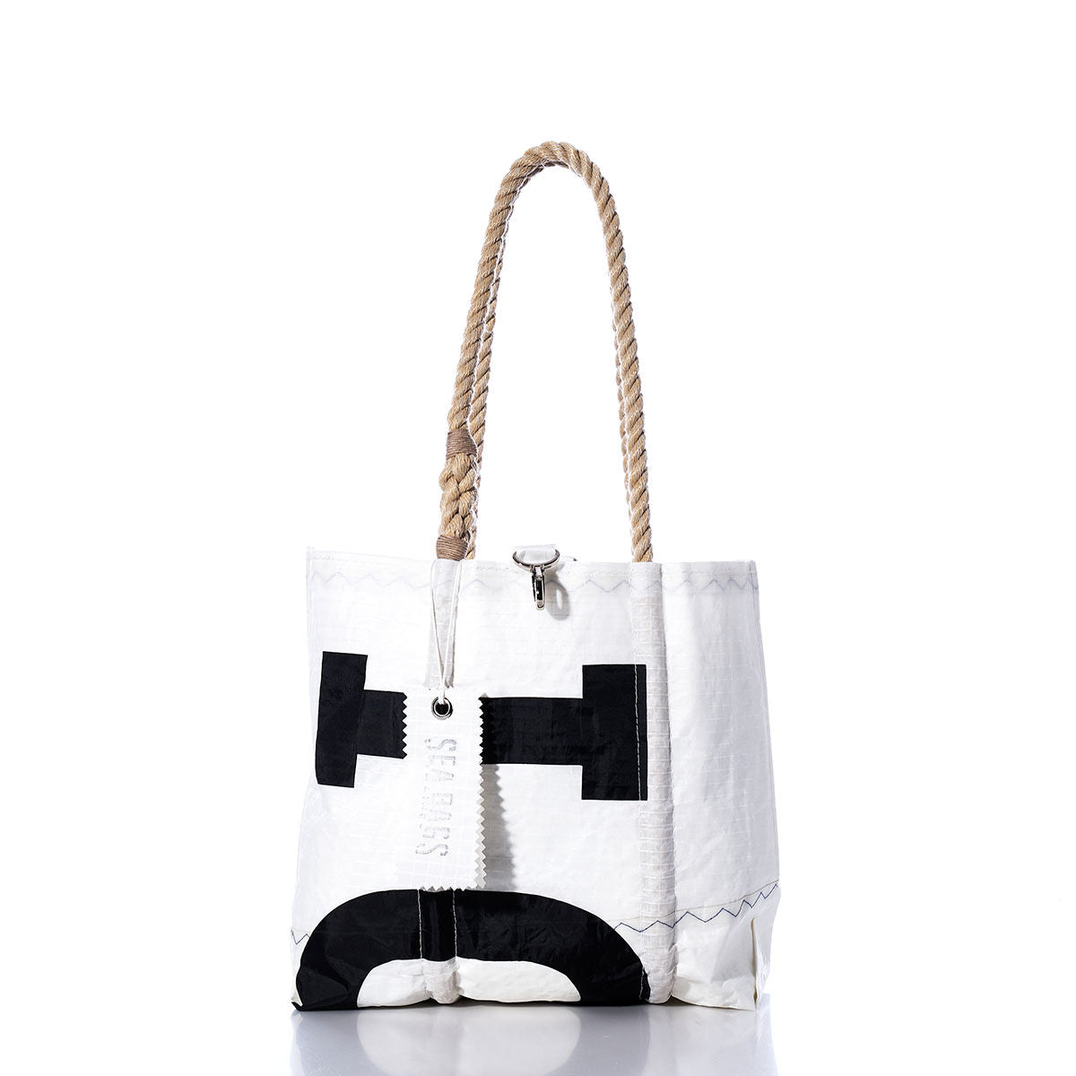 Sea Bags Vintage Interclub Handbag—a white tote bag with black geometric designs, hemp rope handles, and a silver clasp—stands upright on a white background, offering a modern twist on a classic style. by Sea Bags