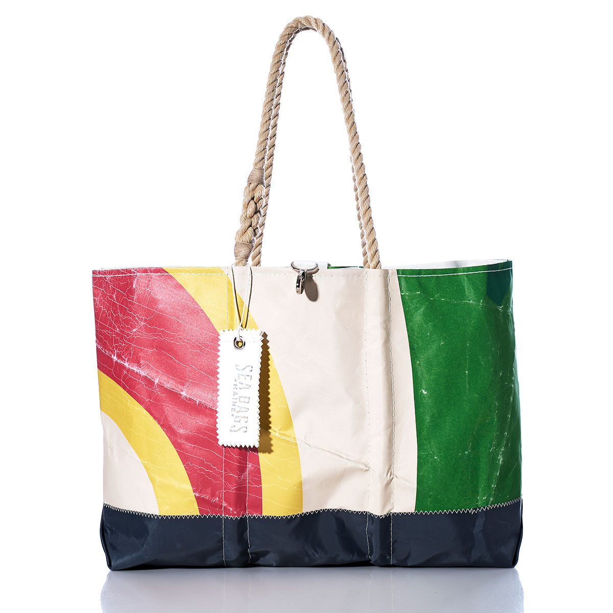 The Vintage Multicolor Ogunquit Beach Tote by Sea Bags features sturdy rope handles and is crafted from recycled sail cloth in vibrant red, yellow, green, and navy panels. A white SEA BAGS tag accents the spacious design, making it perfect for carrying all your beach essentials. by Sea Bags