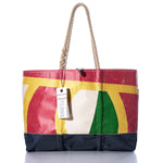 Experience the Vintage Multicolor Ogunquit Beach Tote by Sea Bags, featuring a vibrant abstract pattern, sturdy rope handles, and a signature white tag labeled Sea Bags—all expertly crafted from recycled sail cloth. The tote is showcased against a clean white background. by Sea Bags