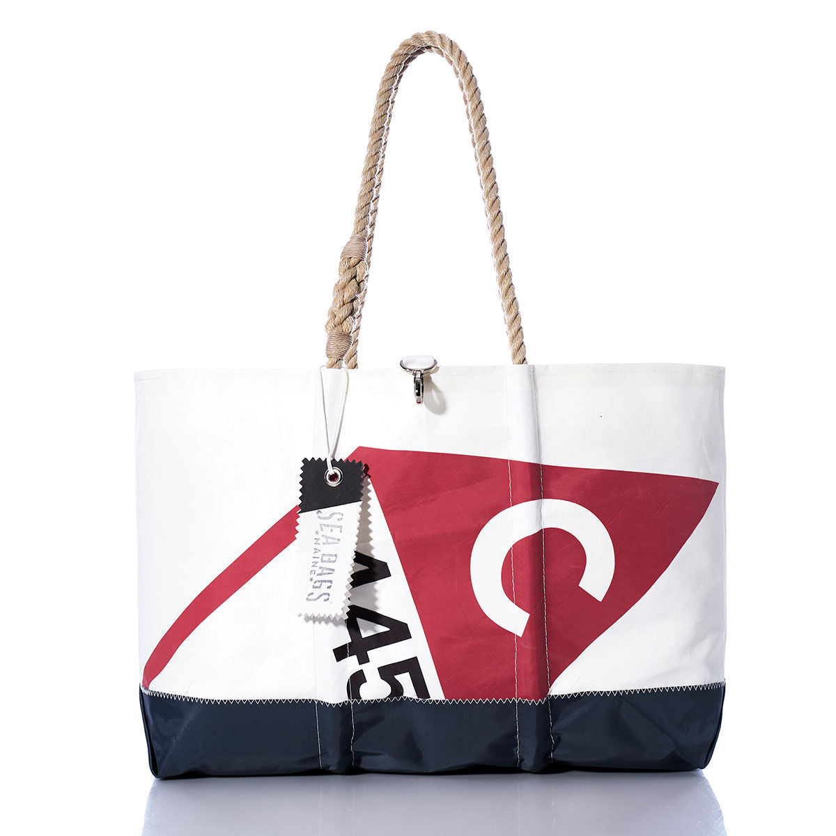 Sea Bags Vintage Catalina 445 Ogunquit Beach Tote—crafted from recycled sail cloth with a white and navy design, rope handles, and a red and white sailboat graphic reminiscent of the iconic Catalina 445—displayed on a reflective surface. by Sea Bags