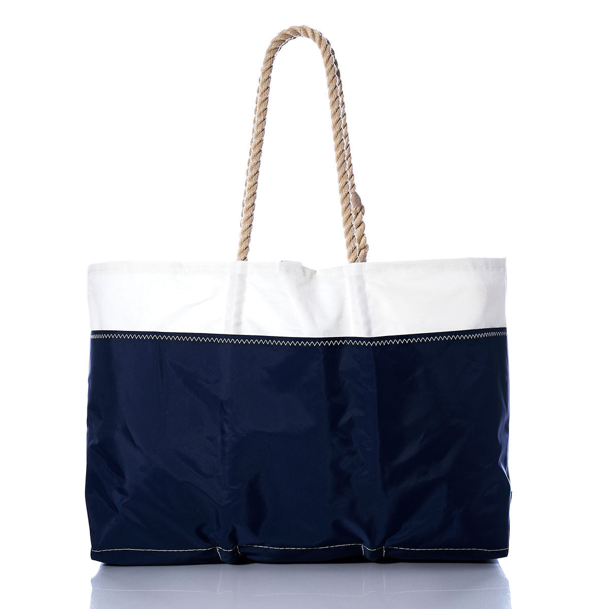 The Sea Bags Vintage Ensign Ogunquit Beach Tote features a white upper section and navy blue lower section with visible stitching and thick rope handles, all crafted from recycled sail cloth. Displayed on a plain white background, this tote blends durability and coastal style. by Sea Bags