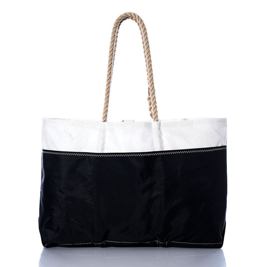 The Sea Bags Vintage Red 2 Ogunquit Beach Tote is a spacious bag made from recycled sail cloth, showcasing a white top, a black bottom, visible stitching, and thick twisted rope handles. The tote is photographed against a white background. by Sea Bags
