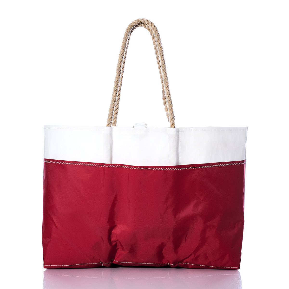 The Sea Bags Vintage J24 Ogunquit Beach Tote, crafted from recycled sail cloth, showcases a vibrant red bottom, crisp white top, and sturdy rope handles. Shown against a white background, this spacious bag is perfect for stylish seaside adventures. by Sea Bags