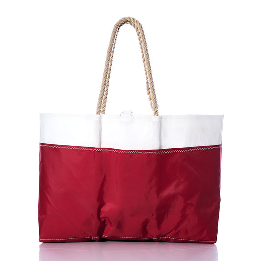 The Sea Bags Vintage J24 Ogunquit Beach Tote, crafted from recycled sail cloth, showcases a vibrant red bottom, crisp white top, and sturdy rope handles. Shown against a white background, this spacious bag is perfect for stylish seaside adventures. by Sea Bags
