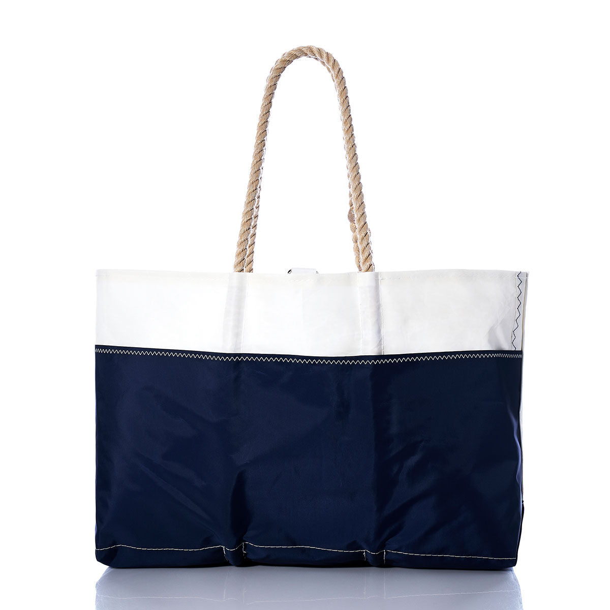 The Sea Bags Vintage Ensign Ogunquit Beach Tote is a two-toned beach tote bag made from recycled sail cloth, showcasing a navy blue lower section and white upper section with two rope handles, photographed against a white background. by Sea Bags