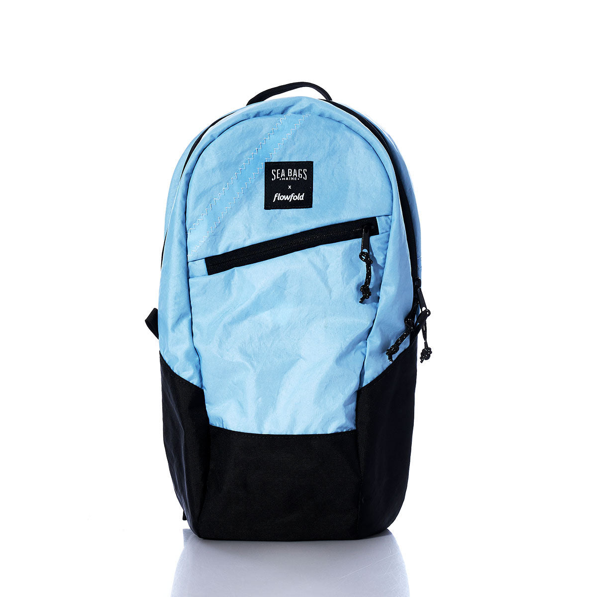 Introducing the Vintage Blue Crew Backpack by Sea Bags—a sustainable backpack crafted from recycled sail cloth in light blue and black. This eco-friendly bag features a front zipper pocket and a branded label, shown against a plain white background. by Sea Bags