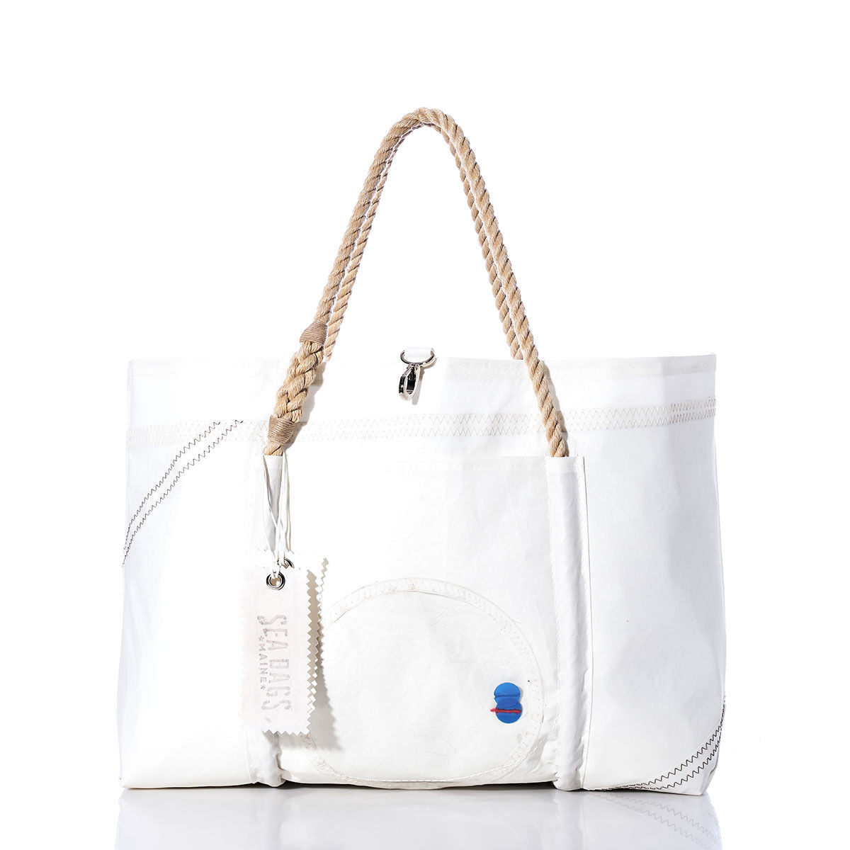 The Vintage Sail Window Wharf Tote by Sea Bags features expert craftsmanship with rope handles, stitched accents, a small blue and red patch, and a signature Sea Bags tag attached to one handle—beautifully made from recycled sail bag materials for timeless style and durability. by Sea Bags
