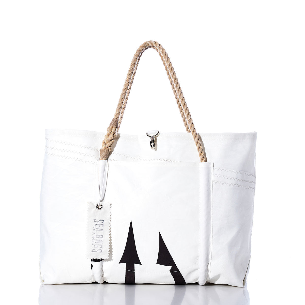Introducing the Vintage Black Trident Wharf Tote by Sea Bags—a white handcrafted tote featuring rope handles, a metal clasp, and a bold black trident arrow design. Finished with a signature Sea Bags tag on the handle, this tote is proudly made in Portland, Maine from recycled sailcloth. The Vintage Black Trident Wharf Tote perfectly blends coastal durability with distinctive style. by Sea Bags