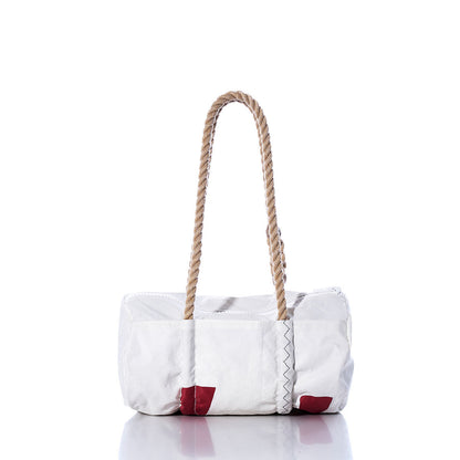 The Sea Bags Vintage Harbor 20 Baguette Bag is a white, rectangular accessory featuring two thick hemp rope handles and small red corner patches. Displayed on a reflective surface against a plain white background, this bag channels nautical charm and contemporary style, drawing inspiration from the classic vintage sail bag. by Sea Bags