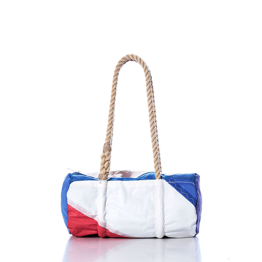 The Sea Bags Vintage Red and Blue Baguette Bag, crafted from recycled sails with blue, white, and red panels and featuring a thick, hand-spliced hemp rope handle, is displayed on a white background. by Sea Bags