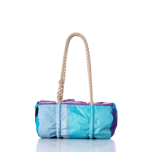 The Sea Bags Vintage Blue and Purple Baguette Bag is a rectangular patchwork handbag made from recycled sails with a thick, hand-spliced hemp rope handle, shown against a white background. by Sea Bags