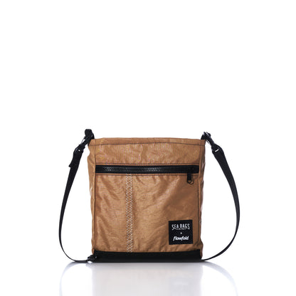 Vintage Caramel Tanbark Voyager Small Crossbody bag in caramel tanbark with black trim, a front zipper pocket, and an adjustable shoulder strap.