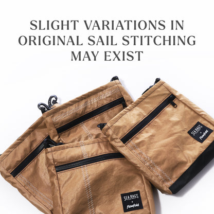 Three caramel tanbark Vintage Caramel Tanbark Voyager Small Crossbody bags made from vintage recycled sail cloth with black zippers and patches; text reads: SLIGHT VARIATIONS IN ORIGINAL SAIL STITCHING.